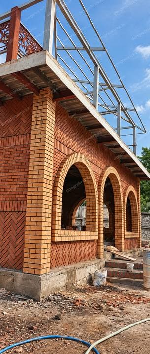 Arched brick building with herringbone infill panels in two brick tones