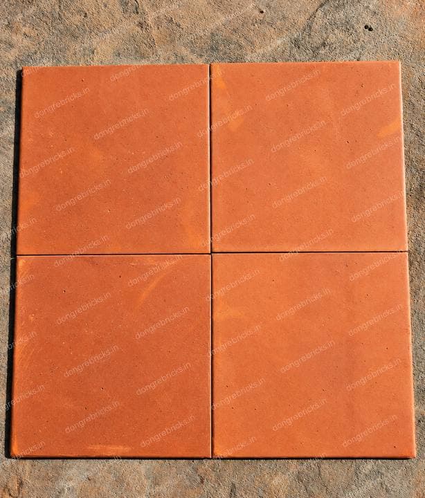Four square terracotta floor tiles laid out as a product sample - the only true product shot in the set